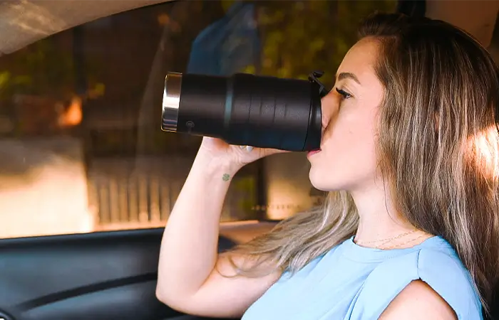 Mulher se hidratando no copo térmico Termolar