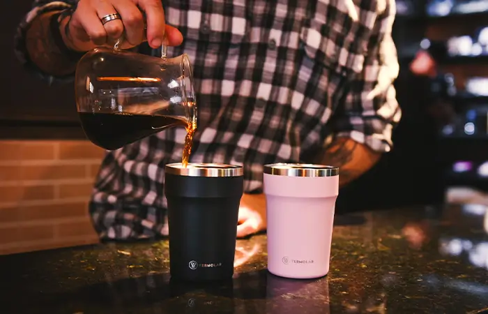 Café gelado sendo colocado no copo térmico Uniq da Termolar